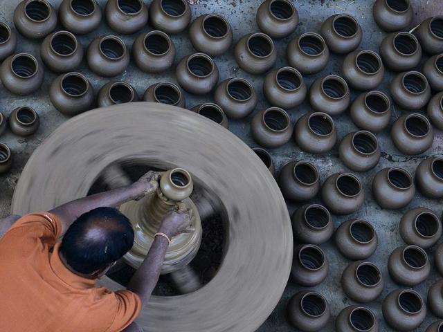 An Indian potter makes earthenware oil pots or 'Diyas' at a workshop, ahead of the forthcoming Diwali festival, on the outskirts of Hyderabad on October 21. Diyas, which are lit and placed around the home, are in heavy demand during the Diwali festival which marks the victory of good over evil and commemorates the time when Hindu god Rama achieved victory over Ravana and returned to his kingdom Ayodhya after 14 years of exile. (AFP)