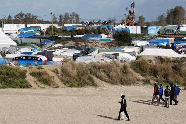 Migrants and no border activists stand on a lookout tower built in the northern part of a camp for migrants called the "Jungle", in Calais, northern France. (REUTERS) Migrants and no border activists stand on a lookout tower built in the northern part of a camp for migrants called the "Jungle", in Calais, northern France. (REUTERS)