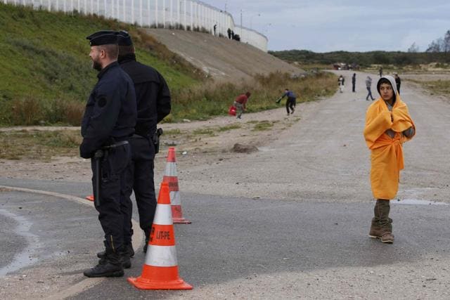 A young migrant looks over at French riot police who patrol near the makeshift camp called the "Jungle". (REUTERS) A young migrant looks over at French riot police who patrol near the makeshift camp called the "Jungle". (REUTERS)