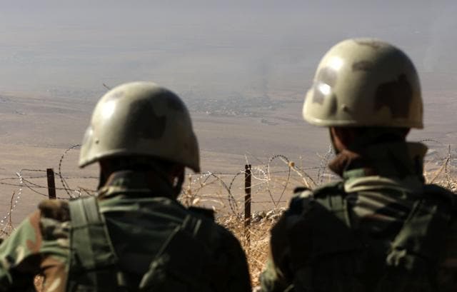 A picture taken from the top of Mount Zardak shows Iraqi Kurdish Peshmerga fighters watching smoke billowing in Nineveh. (AFP Photo) A picture taken from the top of Mount Zardak shows Iraqi Kurdish Peshmerga fighters watching smoke billowing in Nineveh. (AFP Photo)
