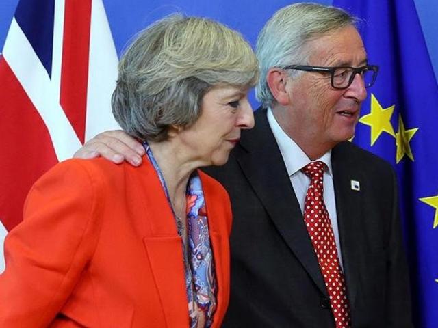 British prime minister Theresa May (L) is welcomed by European Commission President Jean-Claude Juncker at the EC headquarters in Brussels.
