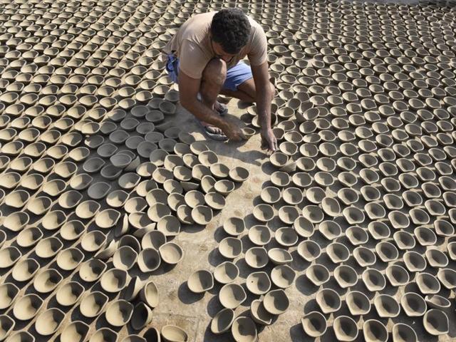 A potter makes earthen lamps for Diwali, in Amritsar on Monday. (Gurpreet Singh/HT Photo)