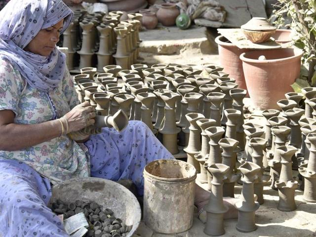 A potter makes earthen lamps for Diwali in Amritsar on Monday. (Gurpreet Singh/HT Photo)