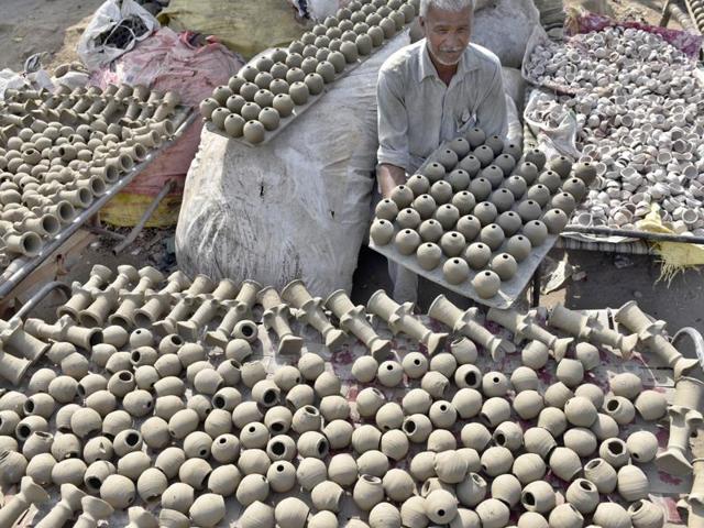 A potter makes earthen lamps for Diwali in Amritsar on Monday. (Gurpreet Singh/HT Photo)