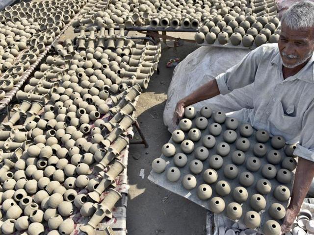 A potter makes earthen lamps for Diwali in Amritsar on Monday. (Gurpreet Singh/HT Photo)