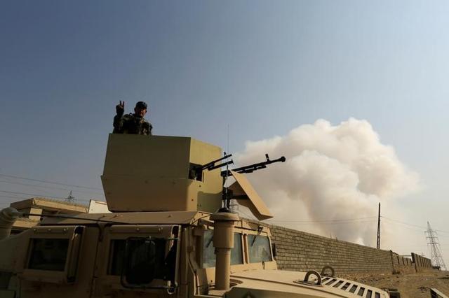 An Iraqi army soldier stands atop of an armoured vehicle as a smoke from a nearby sulfur plant set alight by Islamic State militants rises behind, on the outskirts of Qayyara, south of Mosul, Iraq. (Reuters) An Iraqi army soldier stands atop of an armoured vehicle as a smoke from a nearby sulfur plant set alight by Islamic State militants rises behind, on the outskirts of Qayyara, south of Mosul, Iraq. (Reuters)