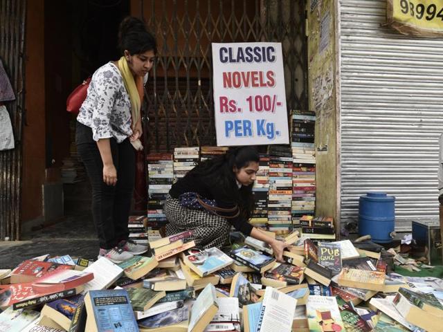 Committed book lovers sort book stacks to find hidden gems of limited edition books at the Sunday bazaar. (Vipin Kumar/HT PHOTO)