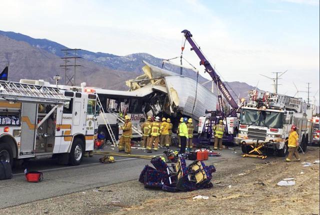 Firefighters used ladders to climb into the bus’ windows to remove bodies, and tow trucks lifted the trailer to make it easier to reach the bus, whose front end was demolished. (AP Photo) Firefighters used ladders to climb into the bus’ windows to remove bodies, and tow trucks lifted the trailer to make it easier to reach the bus, whose front end was demolished. (AP Photo)