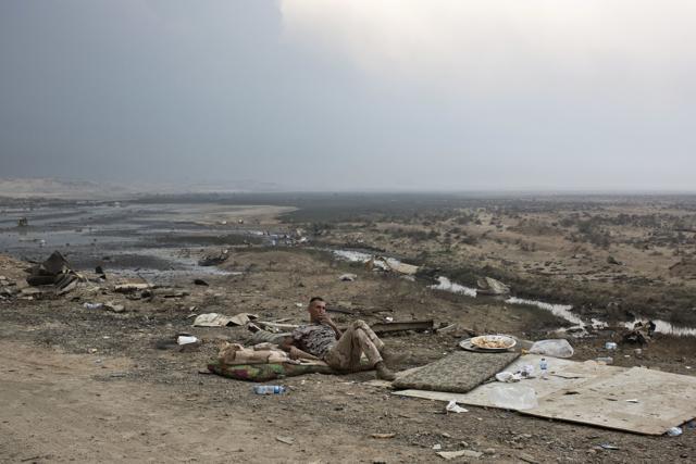 An Iraqi army soldier smokes a cigarette as toxic fumes rise on the horizon in Qayyarah, about 31 miles (50 km) south of Mosul, Iraq. (AP) An Iraqi army soldier smokes a cigarette as toxic fumes rise on the horizon in Qayyarah, about 31 miles (50 km) south of Mosul, Iraq. (AP)