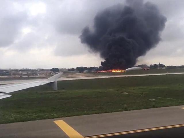 Still image taken from video shows fire trucks aiming their hoses at the burning wreckage of a small plane which crashed at the edge of the runway at the airport in Valletta, Malta, on Monday. (Reuters)