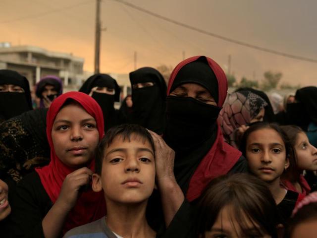 Displaced people gather as they complain about the lack of food supplies outside a processing centre as smoke from burning oil refinery blanketed Qayyara, south of Mosul, Iraq. (REUTERS) Displaced people gather as they complain about the lack of food supplies outside a processing centre as smoke from burning oil refinery blanketed Qayyara, south of Mosul, Iraq. (REUTERS)