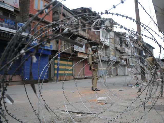 A policeman stands near a barbed wire during curfew in Srinagar,India (File Photo) (Waseem Andrabi /HT) A policeman stands near a barbed wire during curfew in Srinagar,India (File Photo) (Waseem Andrabi /HT)