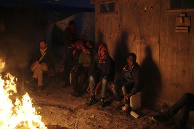 People warm themselves with a fire in the makeshift migrant camp known as "the jungle" near Calais, northern France on Monday Oct. 24, 2016. (AP Photo) People warm themselves with a fire in the makeshift migrant camp known as "the jungle" near Calais, northern France on Monday Oct. 24, 2016. (AP Photo)