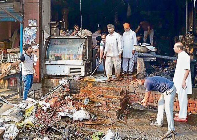 People gathering the charred remains after the fire at a grocery store in Tarn Taran on Monday. (HT Photo) People gathering the charred remains after the fire at a grocery store in Tarn Taran on Monday. (HT Photo)