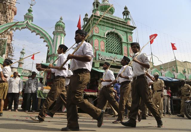 Members of Hindu nationalist Rashtriya Swayamsevak Sangh (RSS), or National Volunteer Organization, wearing the organization's new uniform, march in front of a mosque during a Vijayadashami program in Bangalore.(AP)