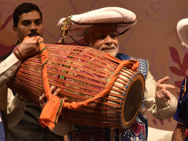 Modi, in tribal attire, beats a drum during the event. (Arun Sharma/HT PHOTO) Modi, in tribal attire, beats a drum during the event. (Arun Sharma/HT PHOTO)