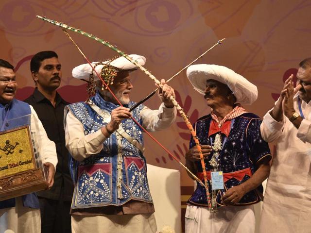 Modi, in tribal attire, tries his hands on the bow and arrow. (Arun Sharma/HT PHOTO) Modi, in tribal attire, tries his hands on the bow and arrow. (Arun Sharma/HT PHOTO)