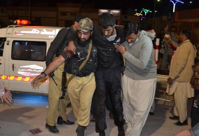 A Pakistani volunteer and a police officer rush an injured person to a hospital in Quetta on Monday after two separate attacks in Pakistan. (AP)