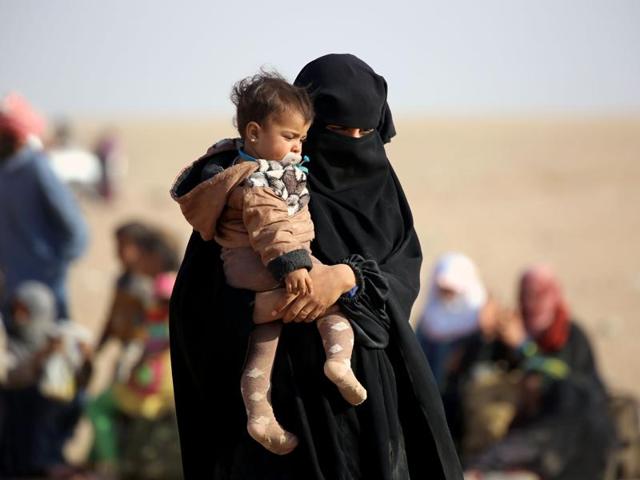 An Iraqi refugee woman who fled Mosul walks with her child as they wait to enter Syria in the desert area of Rajam al-Saliba on the Iraq-Syria border south of al-Hol in Syria's Hassakeh province. (AFP) An Iraqi refugee woman who fled Mosul walks with her child as they wait to enter Syria in the desert area of Rajam al-Saliba on the Iraq-Syria border south of al-Hol in Syria's Hassakeh province. (AFP)