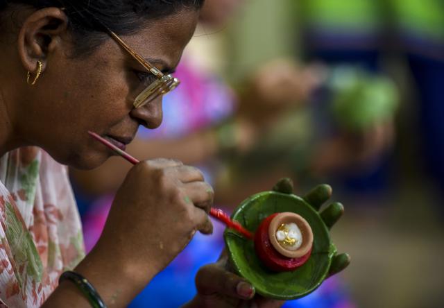 Vanita Ubhare,42, only has partial sight. Ubhare paints a diya at the workshop ahead of Diwali. (Kunal Patil/HT)