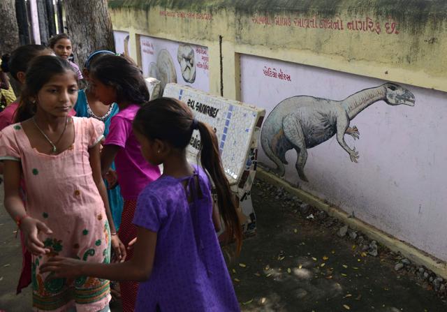 Schoolchildren gather beside a wall painted with dinosaur illustrations in a village near Balasinor. (AFP Photo) Schoolchildren gather beside a wall painted with dinosaur illustrations in a village near Balasinor. (AFP Photo)