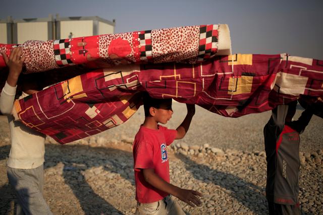 Newly internally displaced boys carry mattresses upon their arrival at Al Khazar camp near Hassan Sham, east of Mosul, Iraq October 26, 2016. (REUTERS) Newly internally displaced boys carry mattresses upon their arrival at Al Khazar camp near Hassan Sham, east of Mosul, Iraq October 26, 2016. (REUTERS)