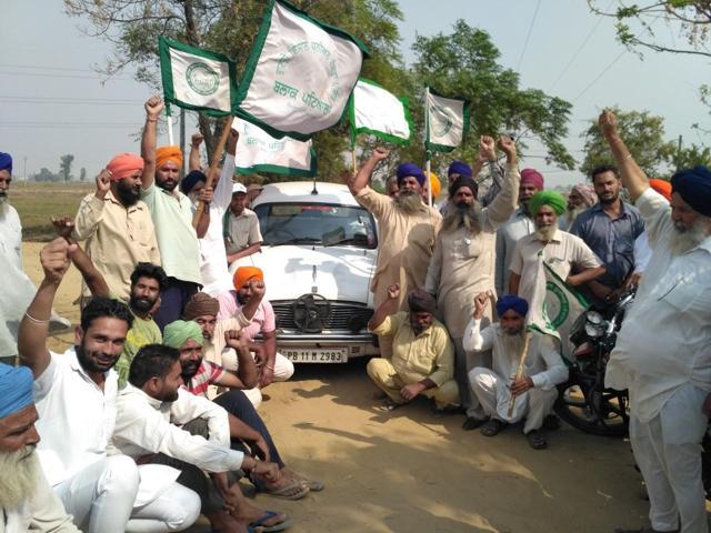 Farmers stage protest before the vehicle of Gurkaran Singh, SDO, PPCB in Fatehpur on Thursday. (HT photo) Farmers stage protest before the vehicle of Gurkaran Singh, SDO, PPCB in Fatehpur on Thursday. (HT photo)