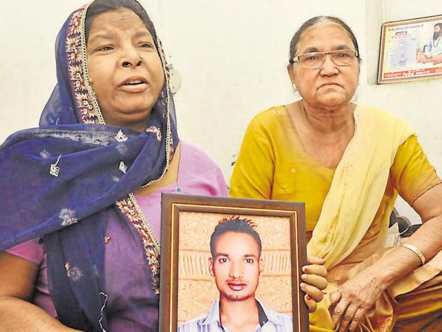 The mother of accident victim Sarbjit Singh holding his picture at her residence in Jalandhar on Thursday.(HT Photo)