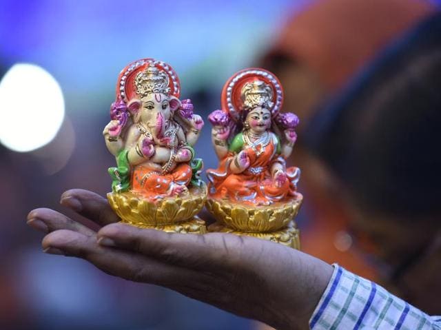 A man buys idols of goddess Laxmi and lord Ganesha from roadside stalls eve of Hindu festival Diwali. (Raj K Raj/HT PHOTO) A man buys idols of goddess Laxmi and lord Ganesha from roadside stalls eve of Hindu festival Diwali. (Raj K Raj/HT PHOTO)