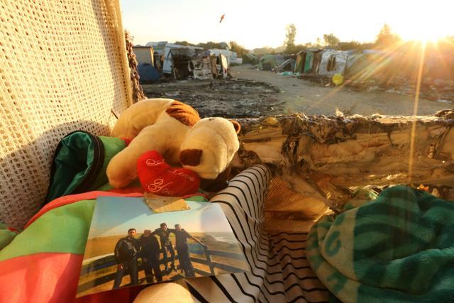 A picture and a teddy bear left behind my migrants lie on a mattress at the demolished "Jungle" migrant camp in Calais in northern France on October 28, 2016. After thousands were bussed out over the past two days, the camp next to the northern port of Calais was virtually deserted. (AFP)