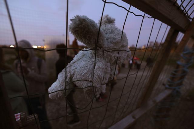 A teddy bear is placed on a fence close to the migrant camp in Calais. (AFP Photo) A teddy bear is placed on a fence close to the migrant camp in Calais. (AFP Photo)