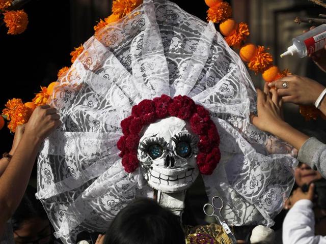 The holiday honours the dead as friends and families gather in cemeteries to decorate their loved ones' graves and hold vigil through the night on November 1 and 2. (AP) The holiday honours the dead as friends and families gather in cemeteries to decorate their loved ones' graves and hold vigil through the night on November 1 and 2. (AP)