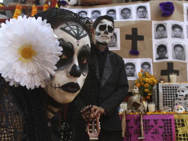 A “catrina” and "calavera” stand in front of a Day of the Dead altar honouring the 43 disappeared rural college students in Acapulco on Wednesday. The government's initial investigation decided the students were killed and incinerated in a fire in 2014 but international experts have cast doubt on this theory and the families have not accepted it. (AP) A “catrina” and "calavera” stand in front of a Day of the Dead altar honouring the 43 disappeared rural college students in Acapulco on Wednesday. The government's initial investigation decided the students were killed and incinerated in a fire in 2014 but international experts have cast doubt on this theory and the families have not accepted it. (AP)