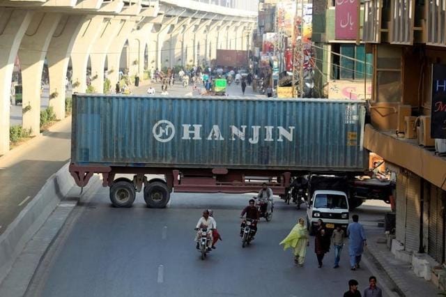 Motorcyclists pass through a gap in a barricade set up using shipping containers near the venue of a planned protest organised by the Awami Muslim League, a political ally of Imran Khan's Pakistan Tehreek-e-Insaf party, in Rawalpindi on Friday. (Reuters) Motorcyclists pass through a gap in a barricade set up using shipping containers near the venue of a planned protest organised by the Awami Muslim League, a political ally of Imran Khan's Pakistan Tehreek-e-Insaf party, in Rawalpindi on Friday. (Reuters)