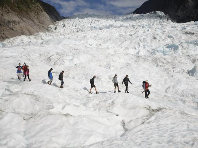 In this file photo, tourists who have taken a helicopter trip onto the Fox Glacier follow a guide in New Zealand. (AP) In this file photo, tourists who have taken a helicopter trip onto the Fox Glacier follow a guide in New Zealand. (AP)