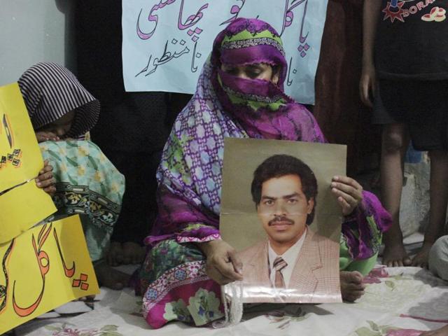 Safia Bano holds a picture of her husband Imdad Ali, who has been on death row since he was convicted in 2001 in a murder case, in Burewala, central Pakistan. (AP FILE) Safia Bano holds a picture of her husband Imdad Ali, who has been on death row since he was convicted in 2001 in a murder case, in Burewala, central Pakistan. (AP FILE)