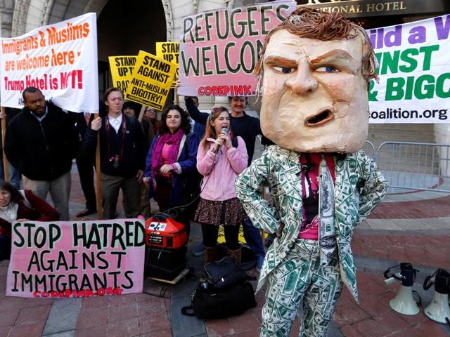 A demonstrator dresses in a Trump costume as people gather to protest against Republican US presidential nominee Donald Trump on the sidewalk, outside the grand opening of his new Trump International Hotel in Washington. (Reuters Photo)