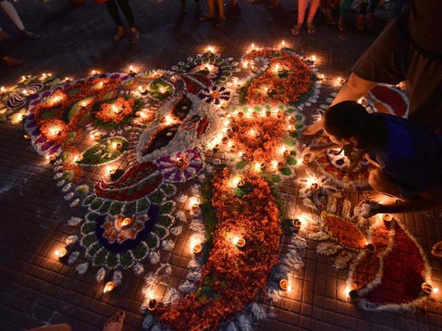 Girls light earthen lamps on a rangoli as they celebrate Diwali in Guwahati Saturday. (AFP) Girls light earthen lamps on a rangoli as they celebrate Diwali in Guwahati Saturday. (AFP)