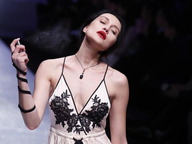 A model sprays perfume as she presents a lingerie collection by Aimer during the Mercedes-Benz China Fashion Week in Beijing on Sunday. (AP)
