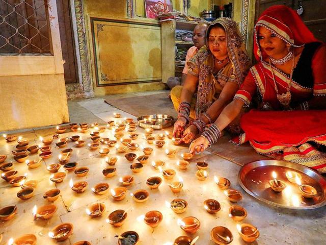 Women light earthen lamps at Ramchandran Ji temple on Diwali in Jaipur on Sunday. (PTI Photo) Women light earthen lamps at Ramchandran Ji temple on Diwali in Jaipur on Sunday. (PTI Photo)