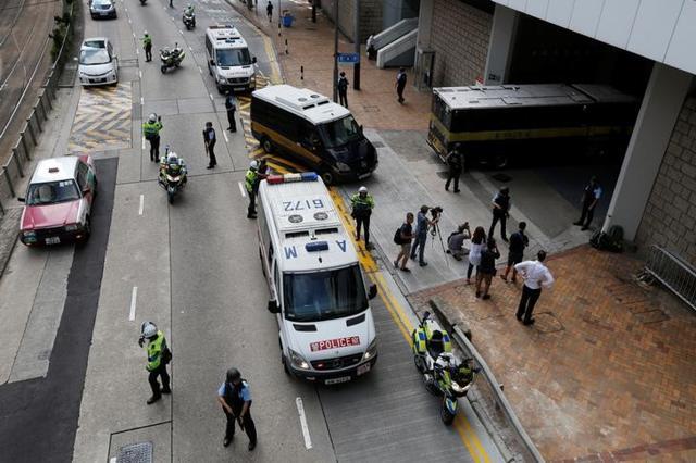 Armed policemen guard the entrance as a prison car carrying British former banker Rurik Jutting enters high court in Hong Kong on October 25. (Reuters)