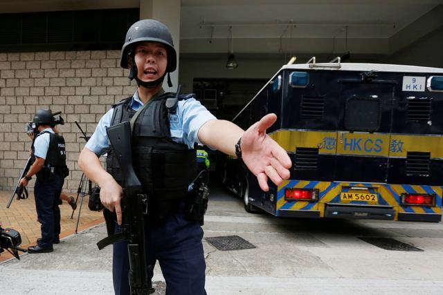 Armed policemen guard the entrance as a prison car carrying British former banker Rurik Jutting enters high court in Hong Kong. (REUTERS)