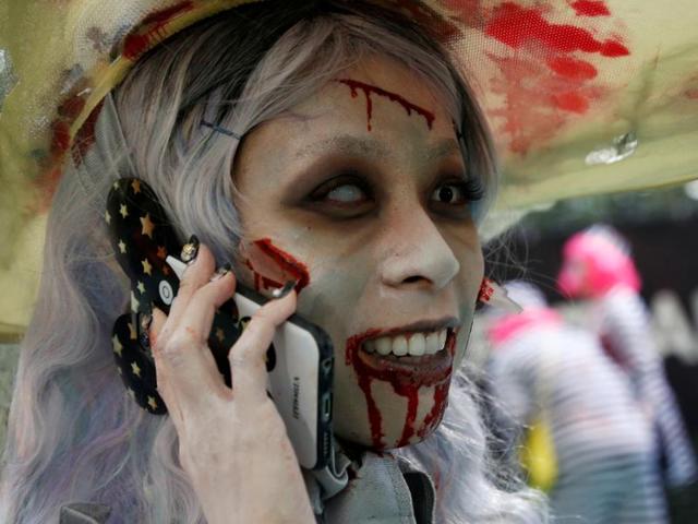A Kawasaki participant in costume is busy with her phone. (REUTERS) A Kawasaki participant in costume is busy with her phone. (REUTERS)