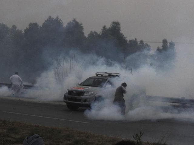 A supporter of Imran Khan's Pakistan Tehreek-e-Insaf party throws a teargas shell towards police during a clash in Hazro, Pakistan, on Monday. Pakistani police launched a nationwide crackdown overnight, arresting at least 1,500 supporters of Khan ahead of a planned lockdown of Islamabad. (AP) A supporter of Imran Khan's Pakistan Tehreek-e-Insaf party throws a teargas shell towards police during a clash in Hazro, Pakistan, on Monday. Pakistani police launched a nationwide crackdown overnight, arresting at least 1,500 supporters of Khan ahead of a planned lockdown of Islamabad. (AP)