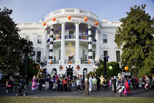 US President Barack Obama and the first lady Michelle Obama hand treats as they welcome children from Washington area and children of military families to trick-or-treat celebrating Halloween at the South Portico of the White House. (AP Photo) 