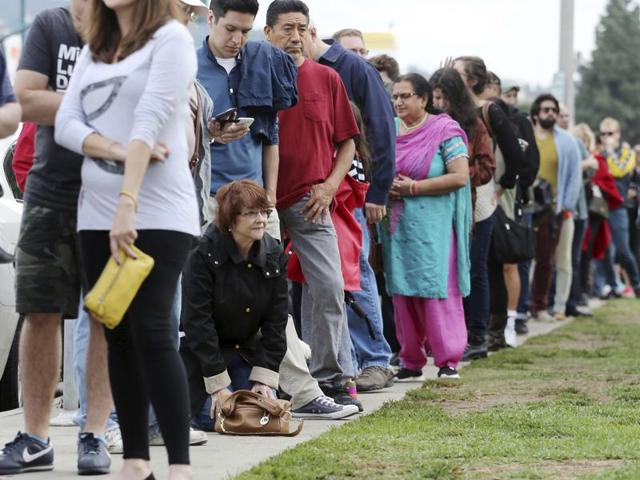 A woman kneels to take a "back break" while waiting in line at a weekend early voting polling place at the North Hollywood branch library in Los Angeles. (AP File Photo) A woman kneels to take a "back break" while waiting in line at a weekend early voting polling place at the North Hollywood branch library in Los Angeles. (AP File Photo)
