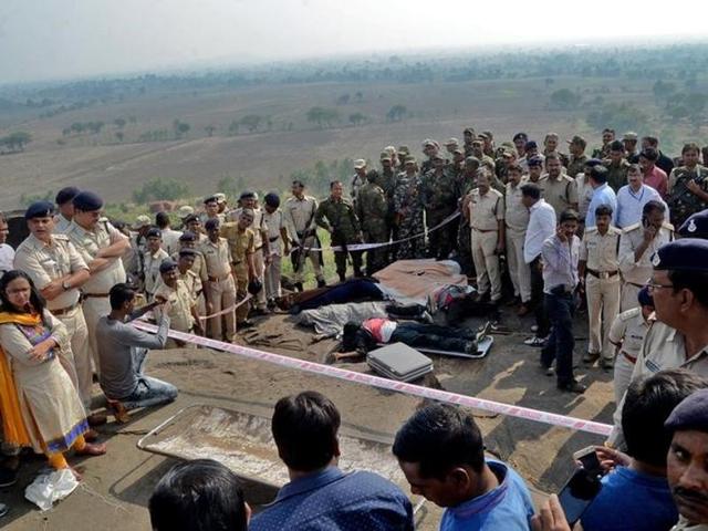 Police officers and Special Task Force soldiers stand beside dead bodies of the suspected members of the banned Students Islamic Movement of India (SIMI), who escaped the high security jail in Bhopal, and later got killed in an encounter.(Reuters)