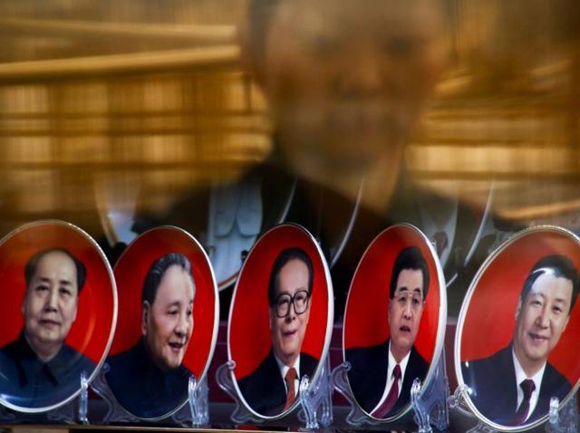 A man looks at a building covered in posters of Chinese President Xi Jinping in Shanghai, China, (File Phjoto)(REUTERS) A man looks at a building covered in posters of Chinese President Xi Jinping in Shanghai, China, (File Phjoto)(REUTERS)