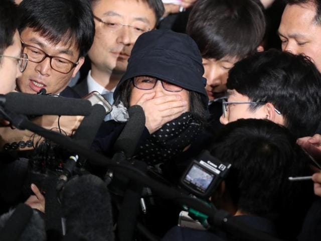 Choi Soon-sil (center wearing a hat) a cult leader's daughter with a decades-long connection to President Park Geun-hye, is questioned by media upon her arrival at the Seoul Central District Prosecutors' Office in Seoul.(AP)
