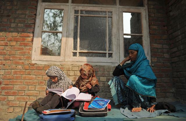 Students study outside a house on the outskirts of Srinagar. Hundreds of schools were ordered to close indefinitely in Kashmir. (AFP Photo) Students study outside a house on the outskirts of Srinagar. Hundreds of schools were ordered to close indefinitely in Kashmir. (AFP Photo)